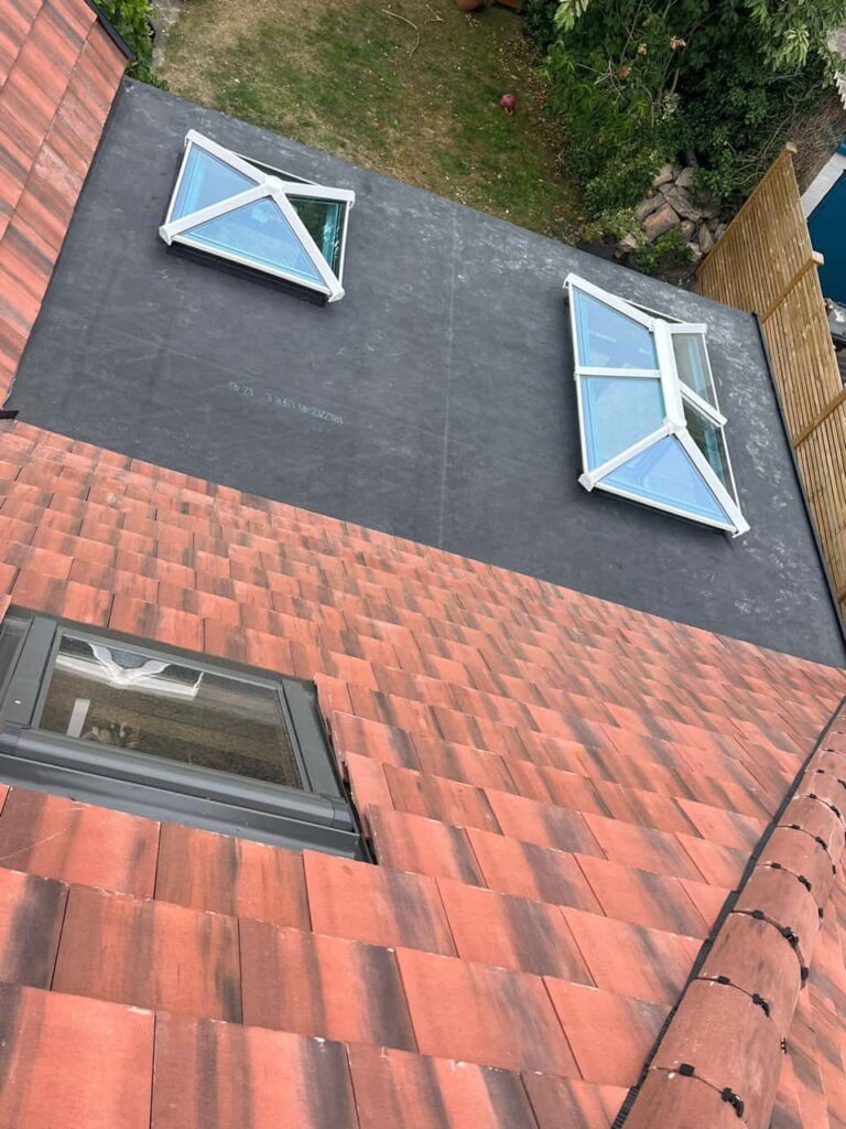 This is a photo taken from the roof ridge looking down a tiled pitched roof on to a flat roof. Works carried out by TRP Roofing Stamford Bridge